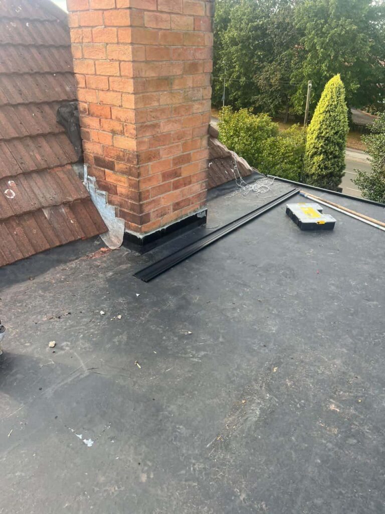 This is a photo of a flat roof which has just been repaired, there is also a chimney stack and some leadwork has also been dressed. Works carried out by Linton Roofing Repairs